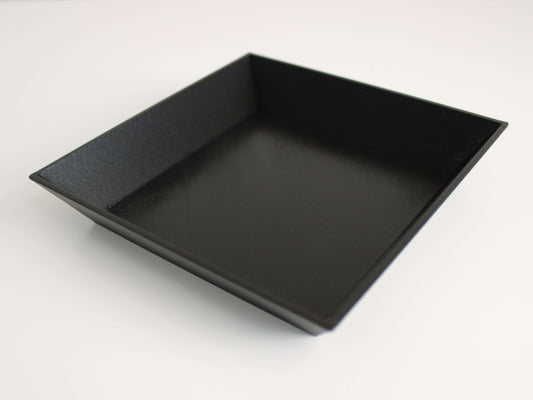A black 3D printed planter saucer with an angled edge