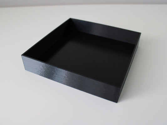 A square black 3D printed planter saucer with a high edge